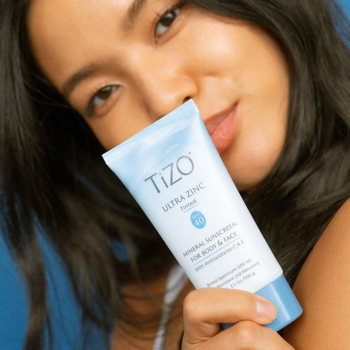 TIZO bottle next to coin showing 3.5 oz size for travel convenience