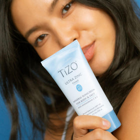 TIZO bottle next to coin showing 3.5 oz size for travel convenience