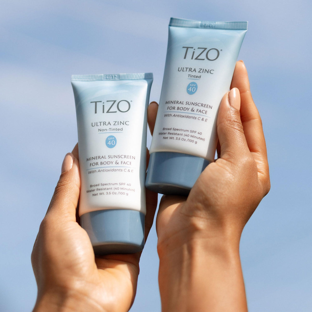 TIZO tube beside everyday items showing 3.5 oz size for travel convenience