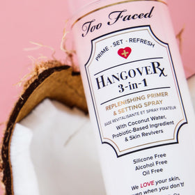 Too Faced bottle held in hand to show travel 1 fl oz scale and portable convenience