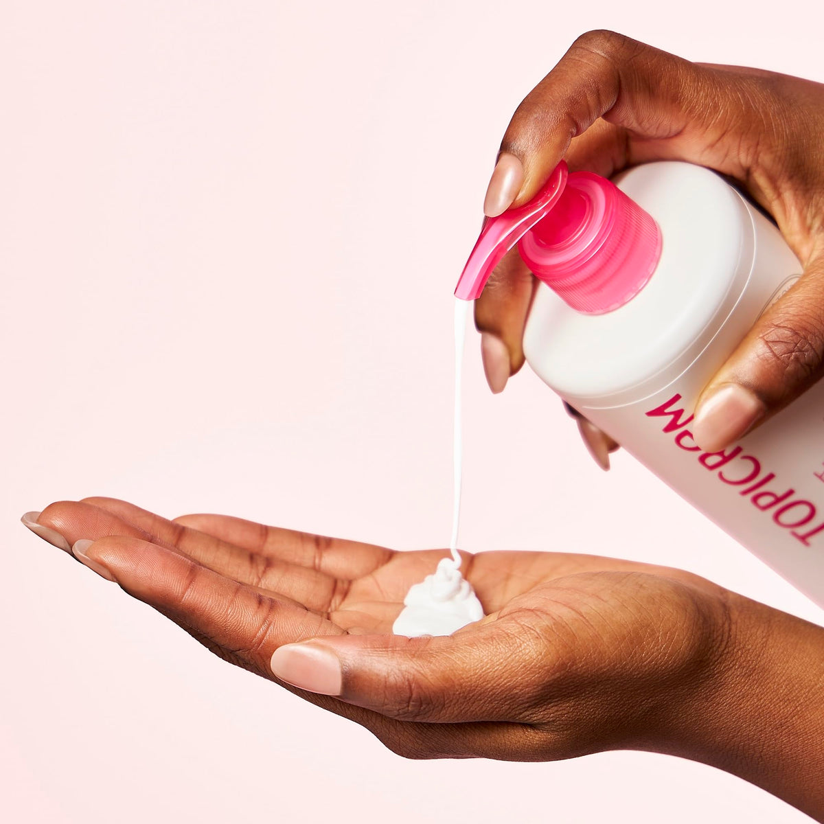 Topicrem bottle next to hand to show 500 ml size and economical benefit