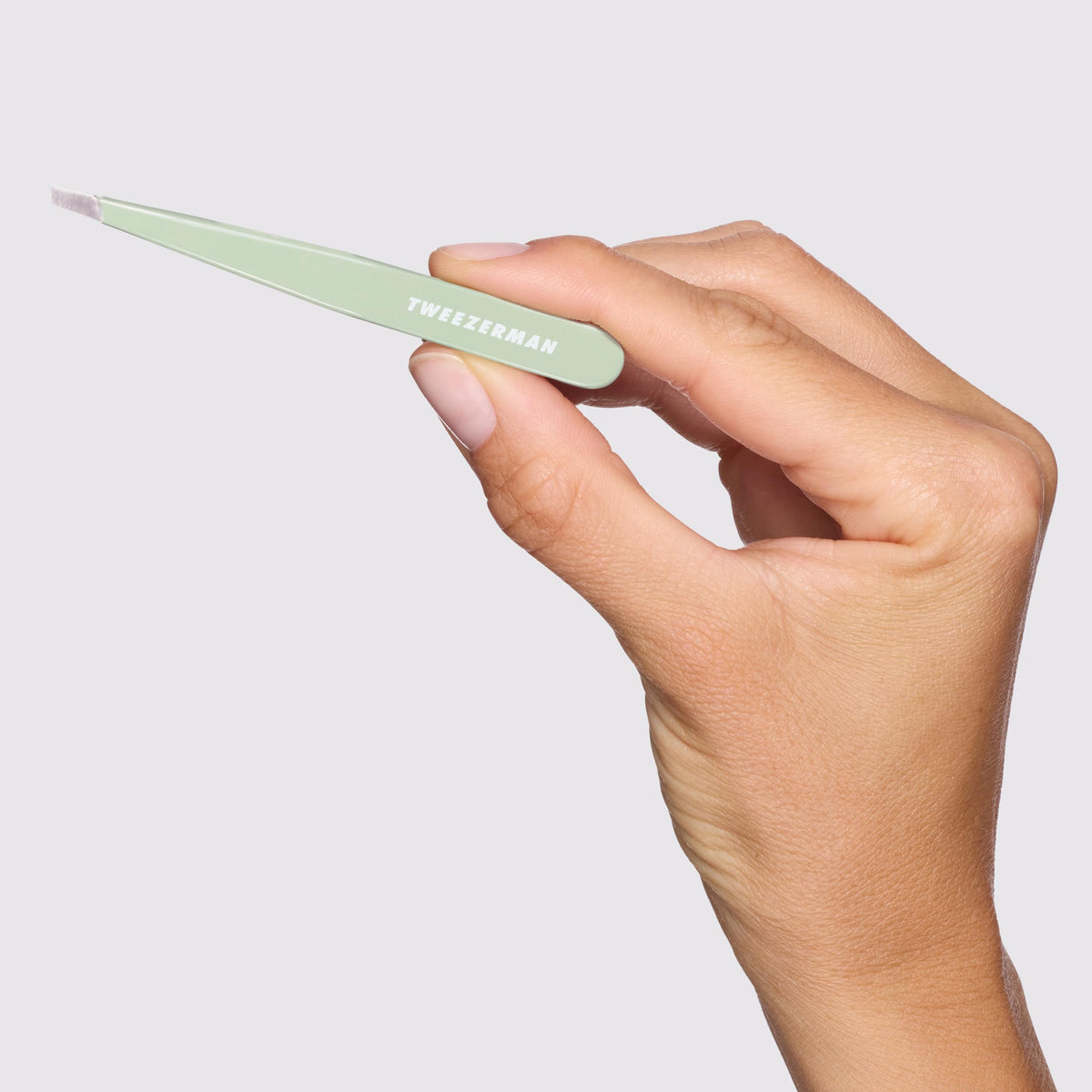 Tweezerman used at an angle over eyebrow illustrating exact hair removal benefit