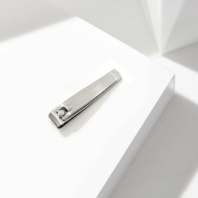 Tweezerman clipper held in hand showing size and control for easy travel benefit