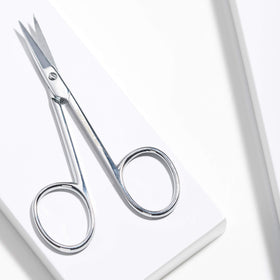 Tweezerman scissors held in hand illustrating size and control for comfortable use