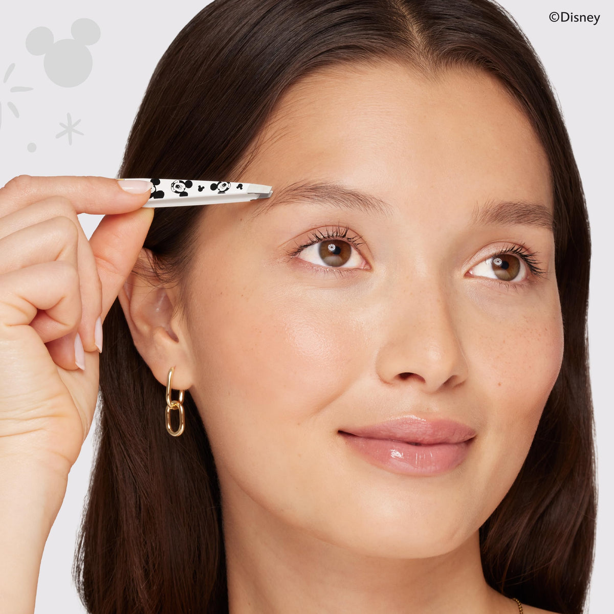 Tweezerman on vanity next to makeup highlighting stylish Disney-inspired appeal