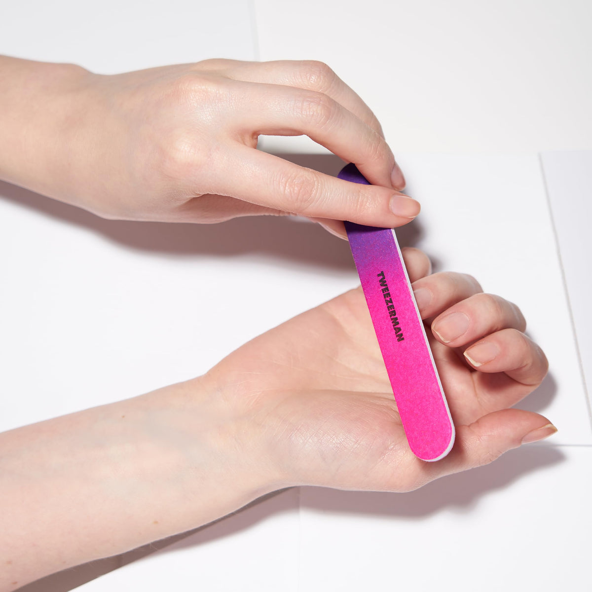 Tweezerman file in use shaping an acrylic nail for precise salon-style results