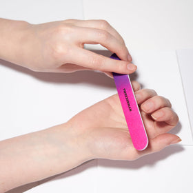 Tweezerman file in use shaping an acrylic nail for precise salon-style results