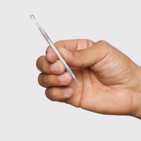 Tweezerman tool in use on forehead demonstrating gentle, hygienic extraction technique