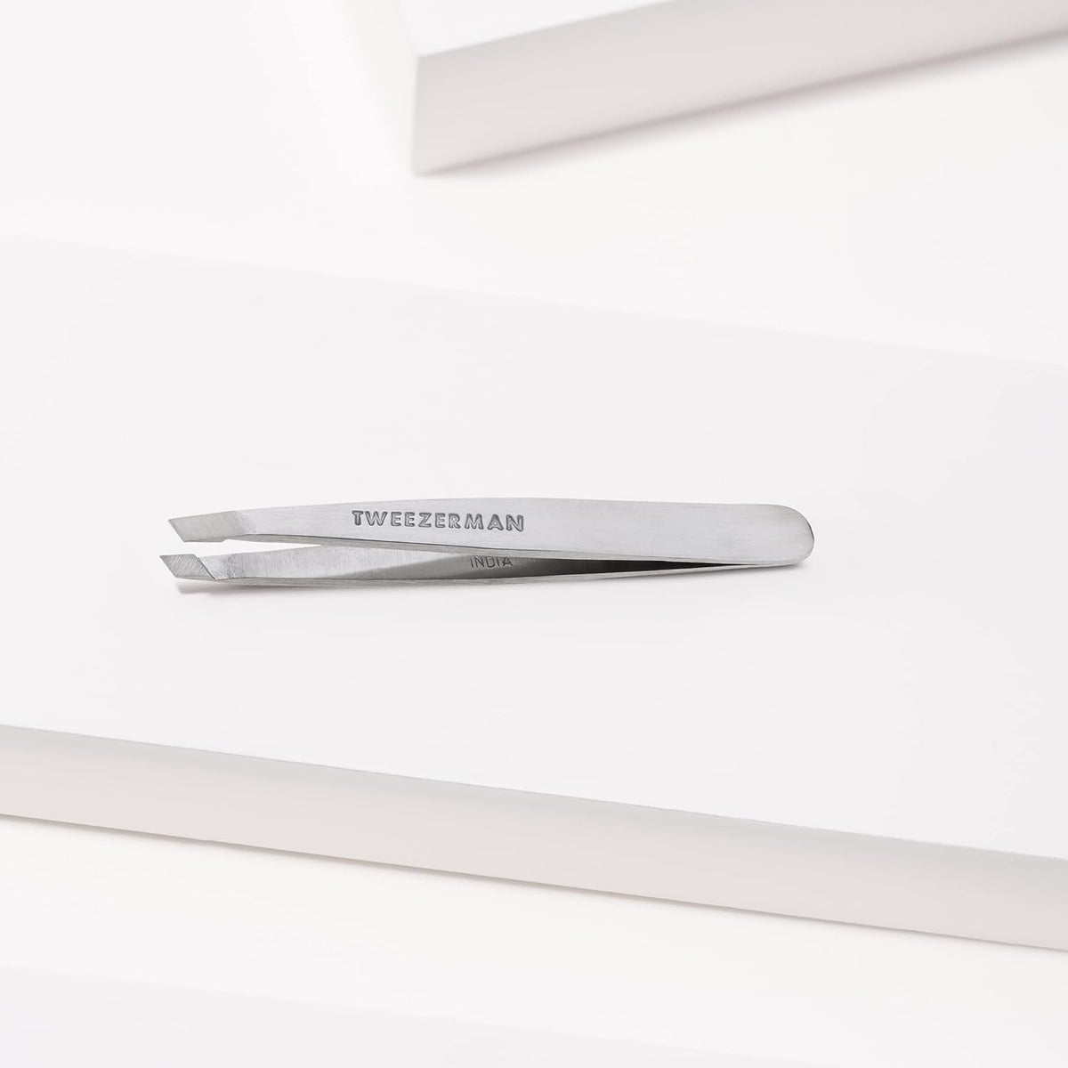 Tweezerman packaging showing brand and durable stainless-steel tool that fits neatly into a kit
