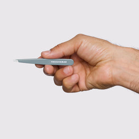 Tweezerman tweezer held in hand showing scale and comfortable grip for precise grooming