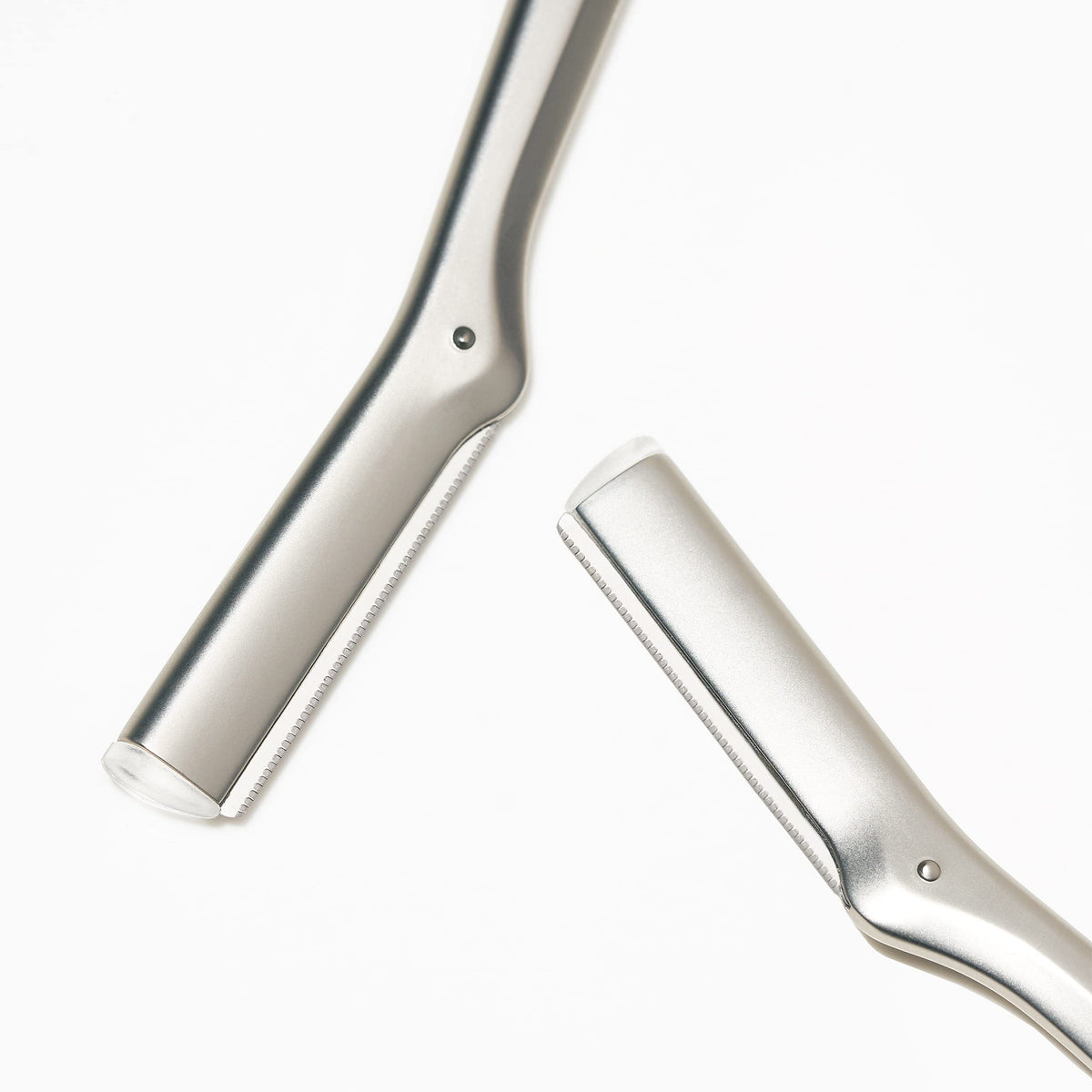 Hand holding Tweezerman razor demonstrating control for safe facial hair removal