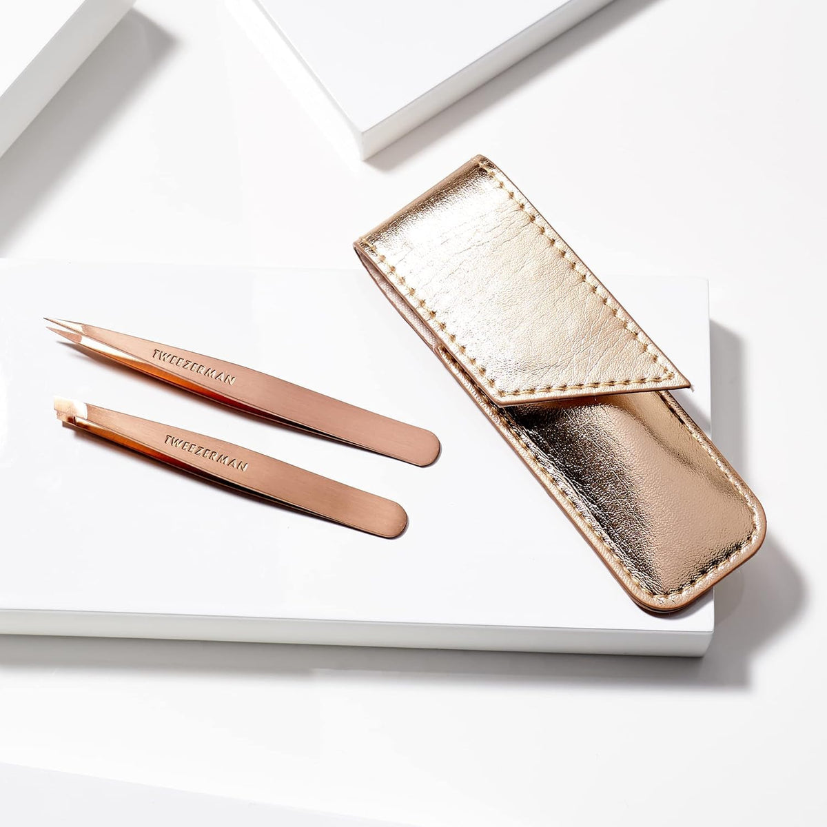 Tweezerman rose gold tweezers in hand to show petite size and improved control during grooming