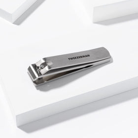 Tweezerman clipper being cleaned with alcohol wipe for quick sanitization