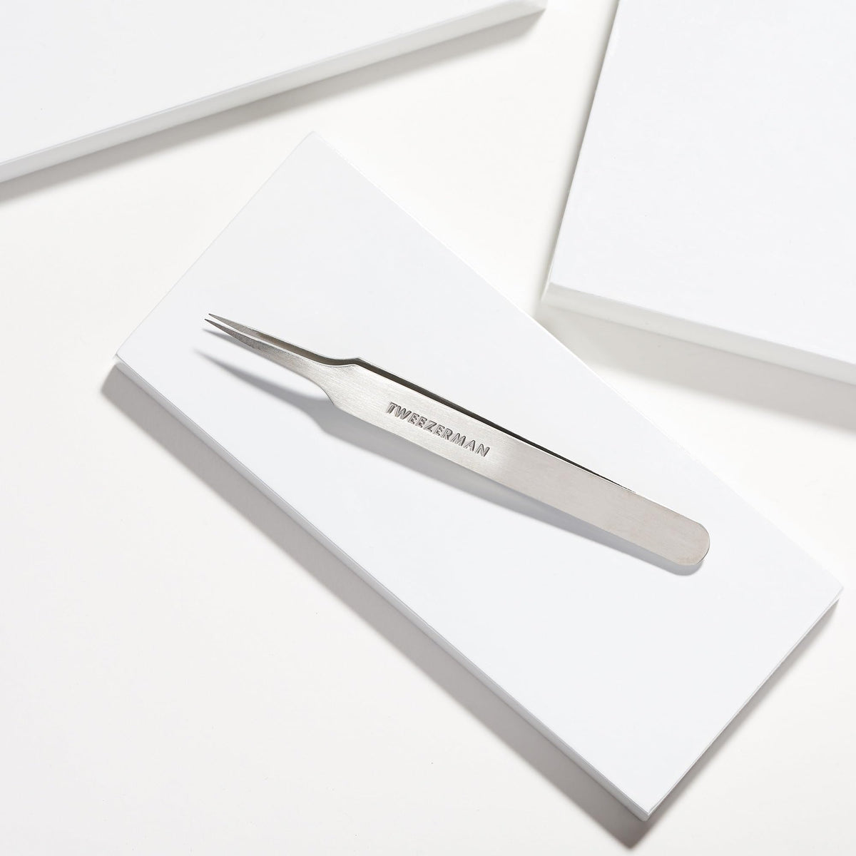 Tweezerman tweezer held in hand illustrating compact size and portability