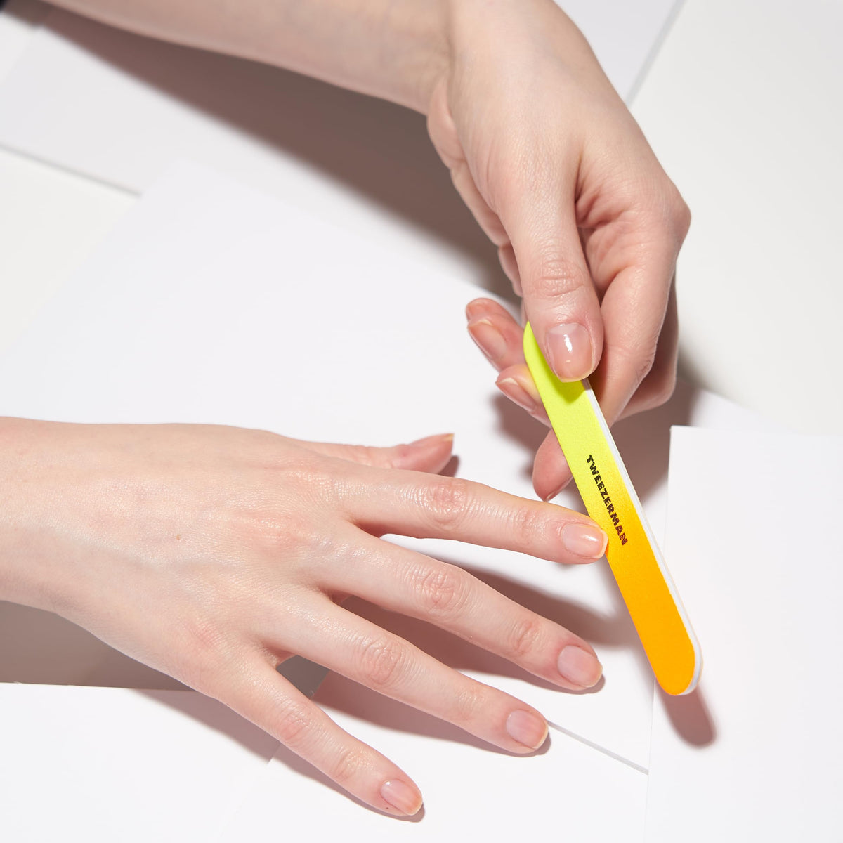 Tweezerman file beside a hand for scale showing convenient size and control