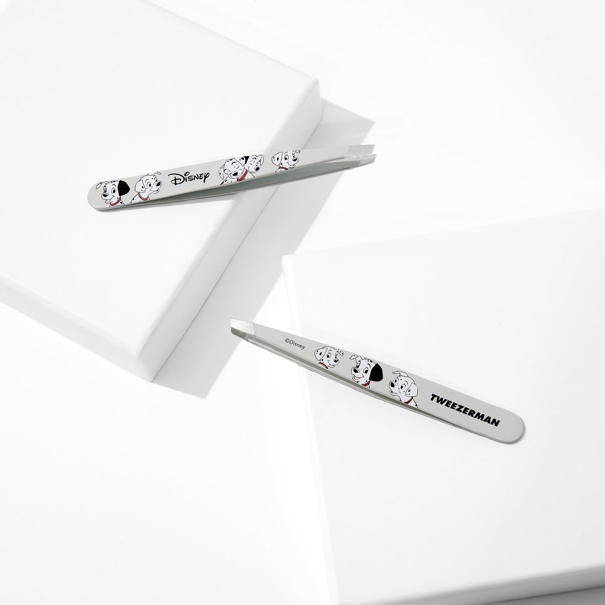 Tweezerman next to ruler for size comparison showing portable stainless-steel tool