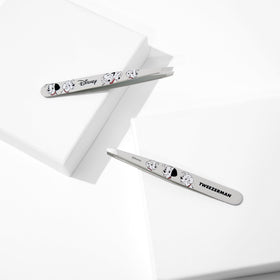 Tweezerman next to ruler for size comparison showing portable stainless-steel tool