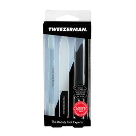 Tweezerman hand holding tools to show scale and portable, travel-friendly benefit