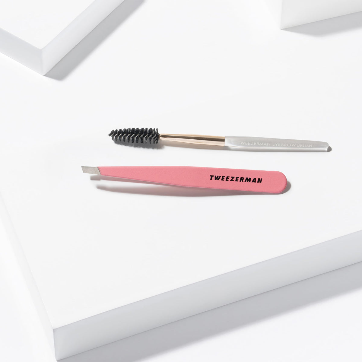 Tweezerman tweezer held in hand illustrating size and fine control for precise plucking