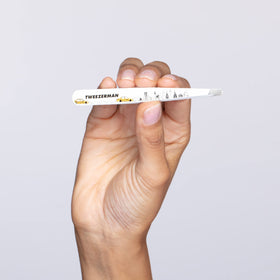 Tweezerman beside coin size comparison showing compact, portable scale