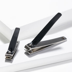 Tweezerman clippers beside a coin for size comparison and travel-friendly portability