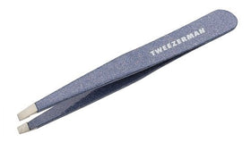 Tweezerman placed on warm washcloth illustrating prep routine for gentler hair removal