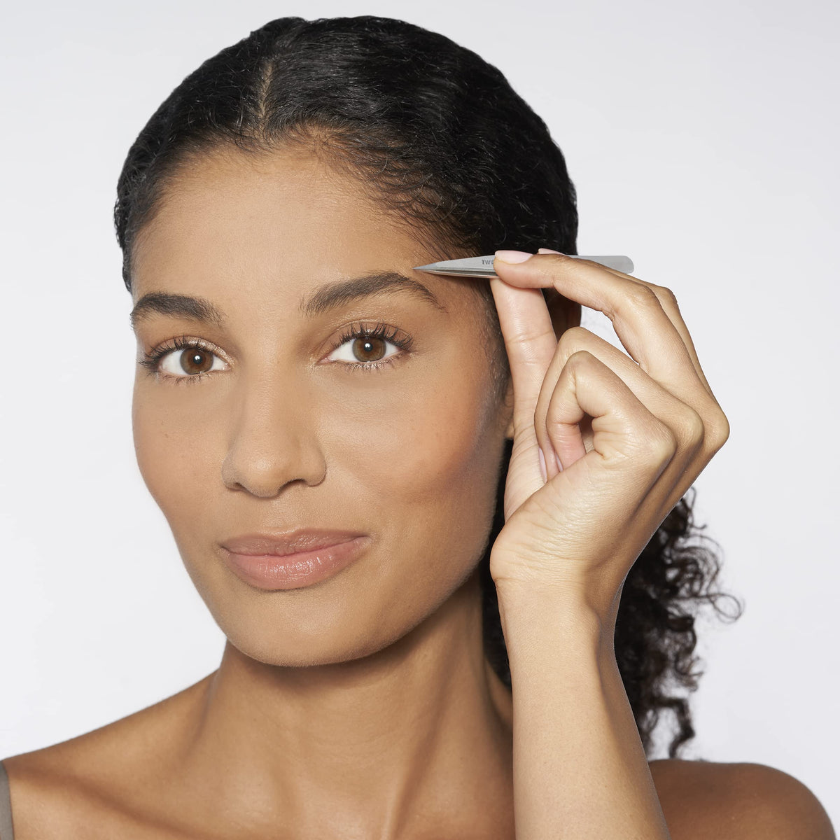 Tweezerman slant tweezer tip closeup highlighting precise hand-filed edge for accurate brow shaping
