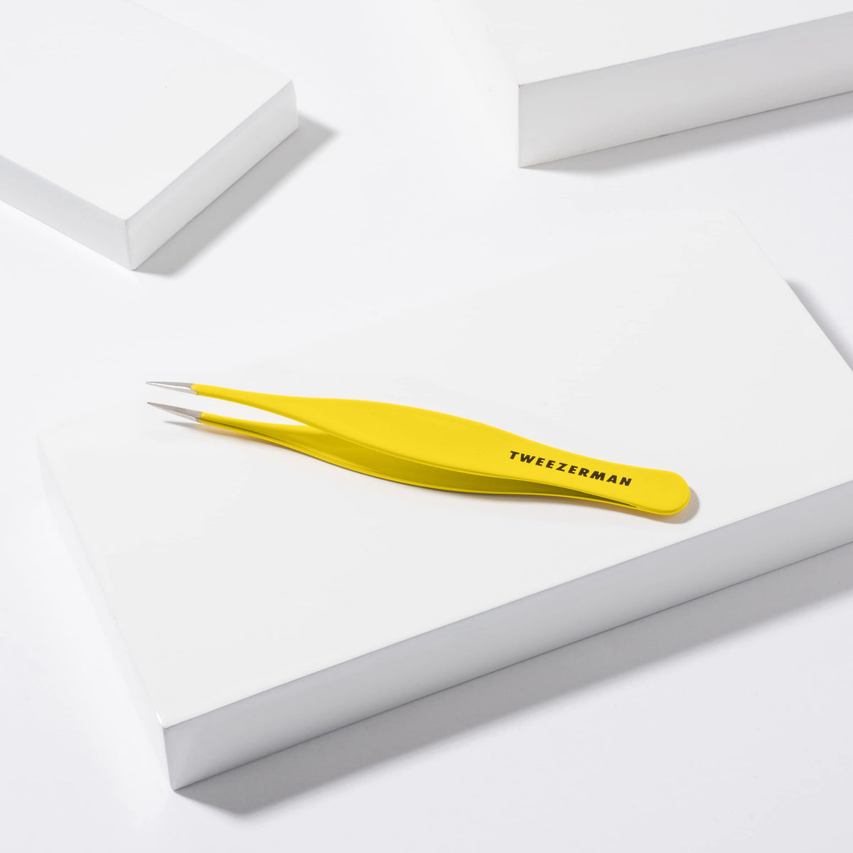 Tweezerman splintertweeze beside a ruler showing compact size for travel kits