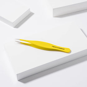 Tweezerman splintertweeze beside a ruler showing compact size for travel kits