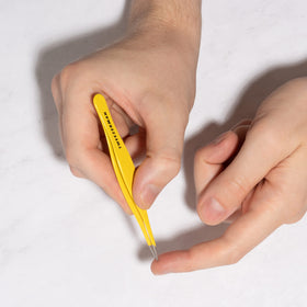 Tweezerman splintertweeze in use removing a splinter from a fingertip safely
