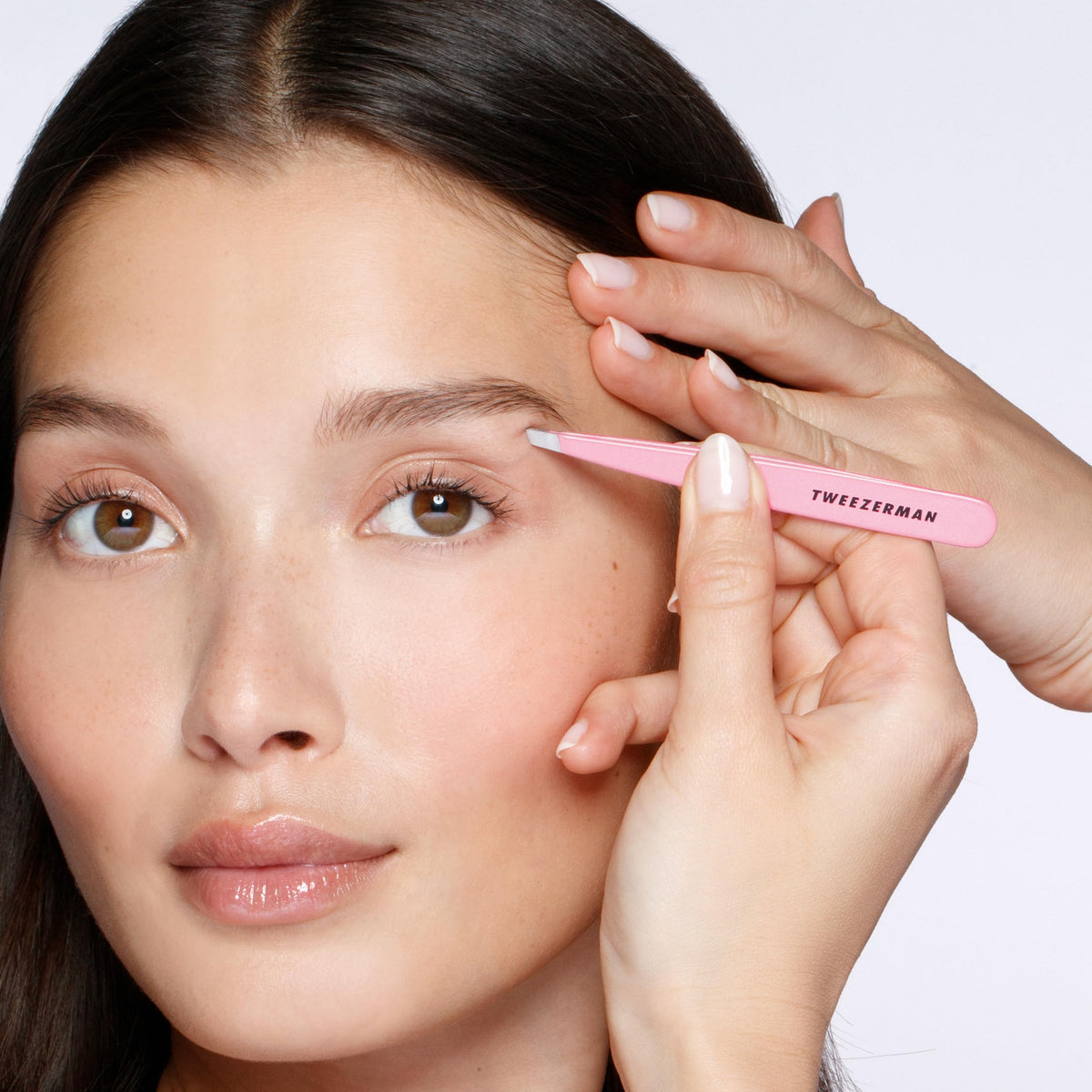 Tweezerman tea rose held in hand to show scale and comfortable calibrated tension for accuracy