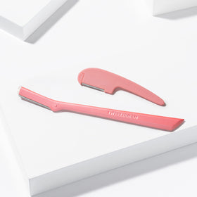 Tweezerman razor held in hand demonstrating size and comfortable ergonomic grip