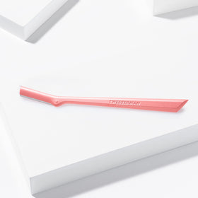 Tweezerman razor held in hand demonstrating compact size and control
