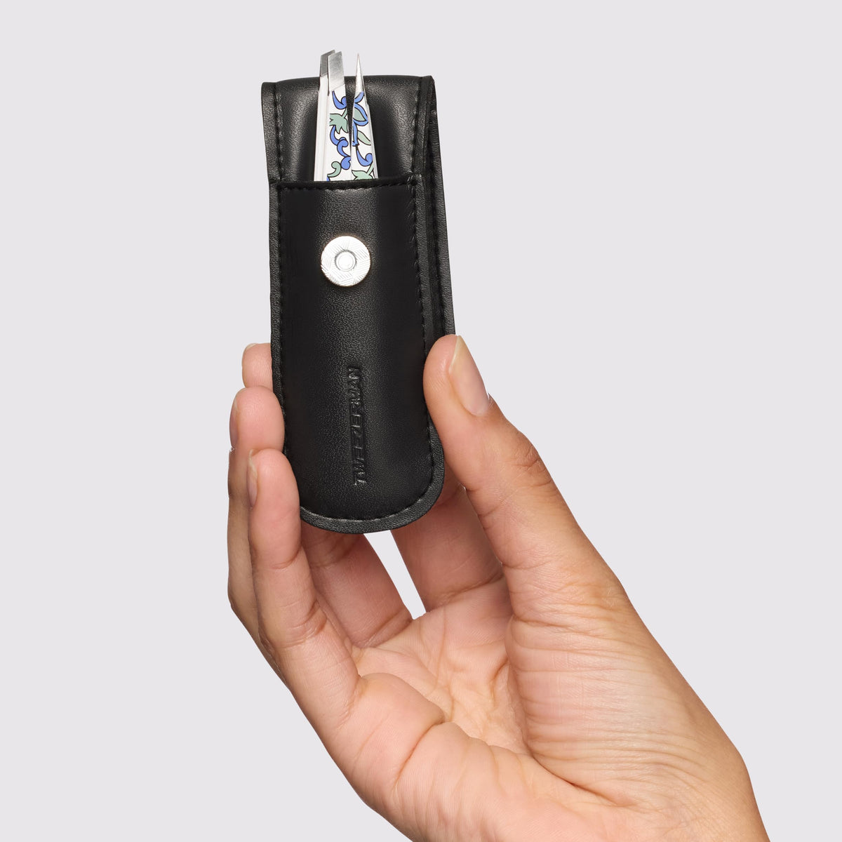 Tweezerman tweezer held in hand to show petite scale and easy control