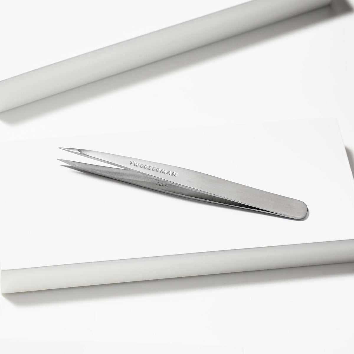 Tweezerman tweezer in use removing a fine hair to demonstrate clean extraction benefit