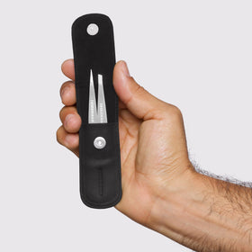 Tweezerman tweezers in case next to ruler showing compact scale for easy travel and everyday carry