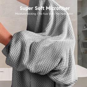 Umisleep towel alongside hand showing large 40x30 size for full hair coverage