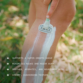 Ursa Major hand applying cream to wet skin for easy razor glide