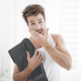 Utopia Towels next to a hand for scale showing compact size