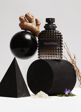 Valentino bottle held in hand for scale demonstrating compact travel-friendly size
