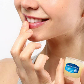 Applying Vaseline Lip Therapy to lips for softening and protection