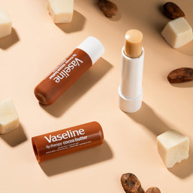 Vaseline lip balm beside a coin illustrating compact size and travel convenience