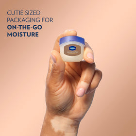 Vaseline jar in hand scale comparison showing compact travel-friendly size