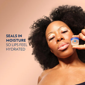 Vaseline jar beside travel bag illustrating on-the-go lip moisturization