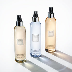Pears and green tea leaves beside Vera Wang bottle highlighting natural notes