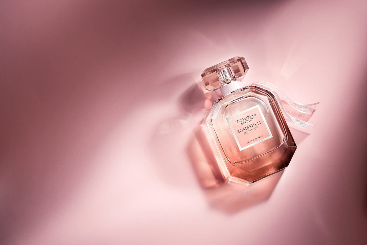 Victoria's Secret bottle held in hand to show scale benefit: clear 1.7 fl oz size reference