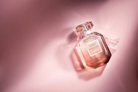 Victoria's Secret bottle held in hand to show scale benefit: clear 1.7 fl oz size reference