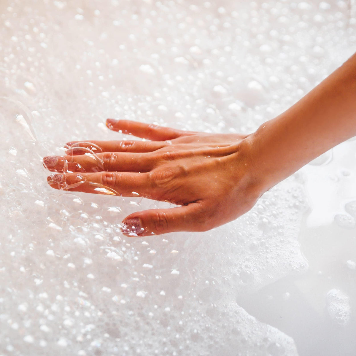 Village Naturals creamy foam texture on hand demonstrating rich bubbles and softness
