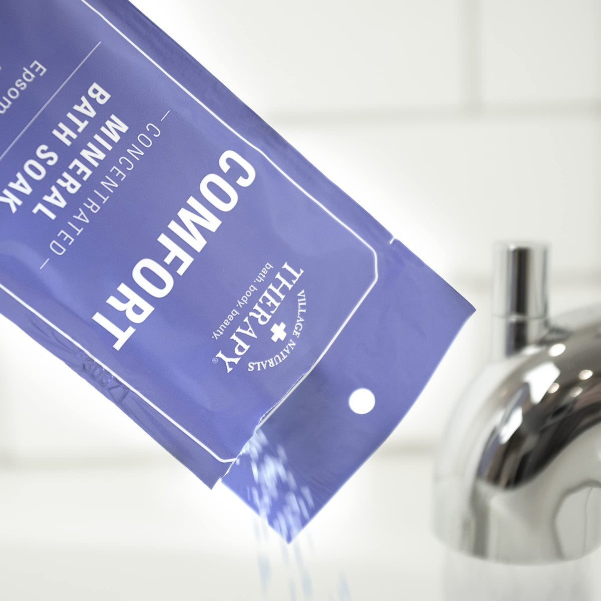 Lifestyle bathroom scene with Village Naturals Therapy packets creating relaxing atmosphere