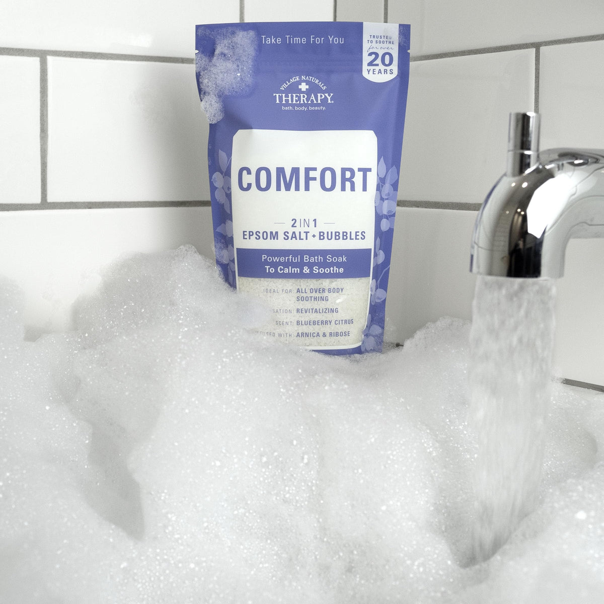 Village Naturals Therapy in bathroom soak scene conveying relaxing home spa benefit